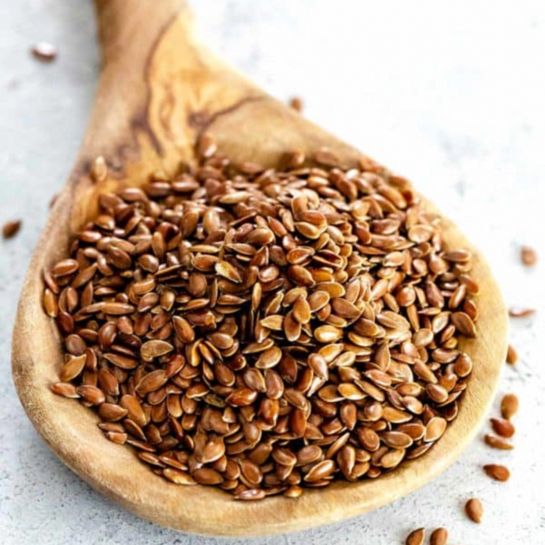 Organic brown flaxseeds linseeds on wooden spoon
